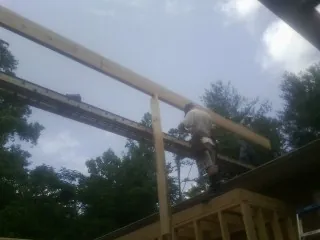 Carpenter setting a ridge beam over a new addition frame — Ice Dam Removal by Roofing Brothers in Demarest